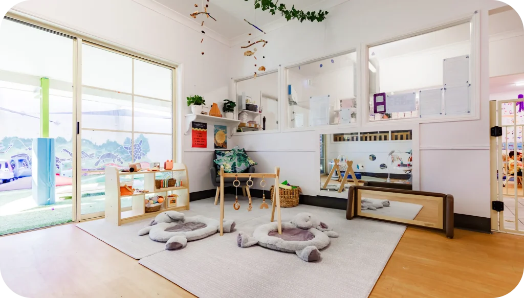 Calm nursery learning area with soft mats, mirrors and sensory play equipment at Lollipop Lane Childcare