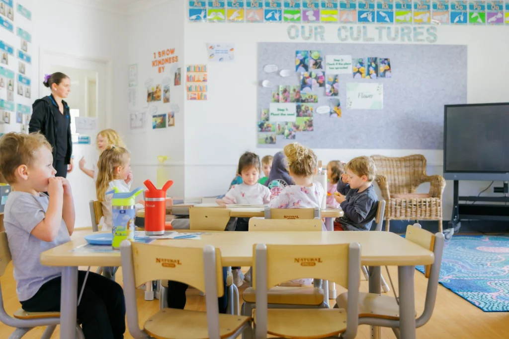 Children seated together at tables during an indoor learning activity at Lollipop Lane Childcare